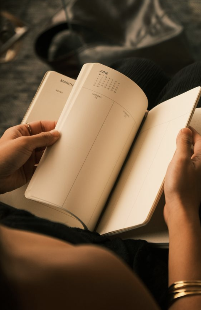 Mãos escrevendo em um caderno aberto